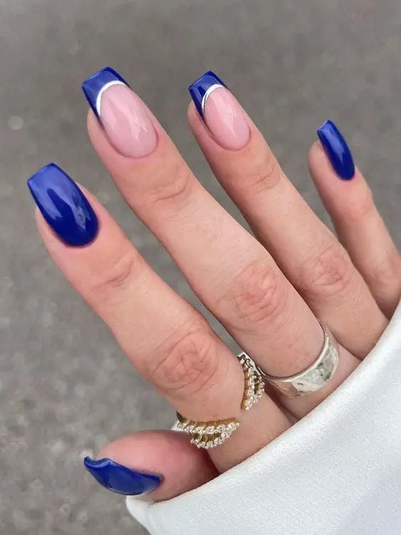 mão feminina mostrando unhas combinando cores azul marinho e prata