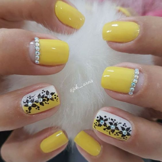 exemplo de unha com esmalte amarelo combinado com pedras brilhantes