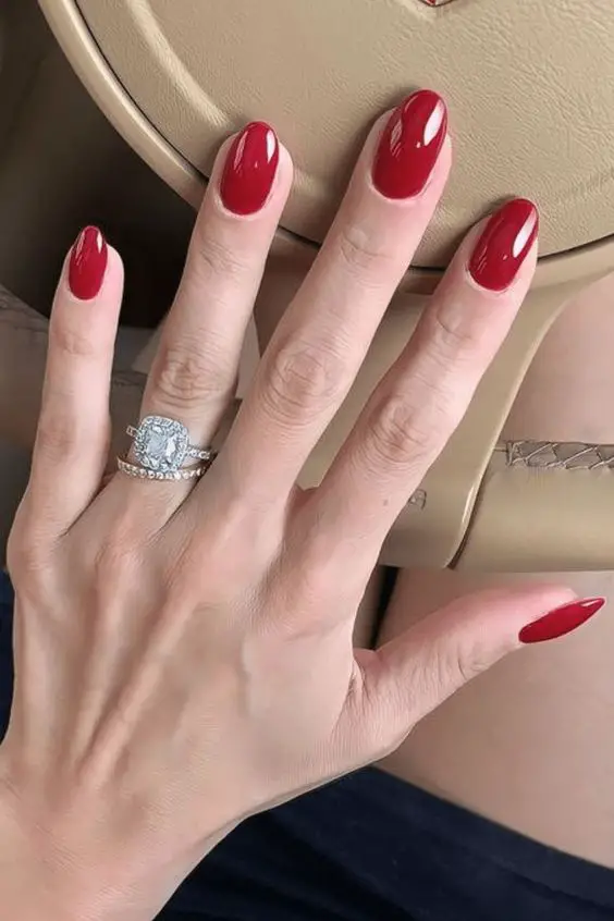 Modelo de unhas curtas ovais com esmalte vermelho