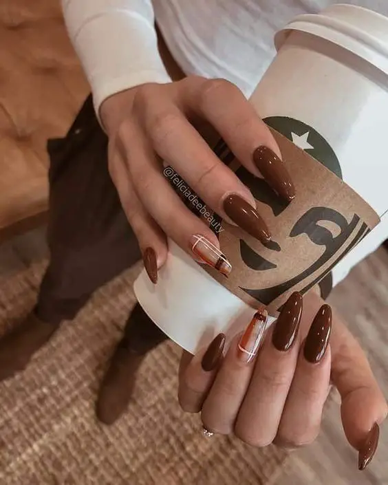 mulher segurando café mostrando unhas combinando