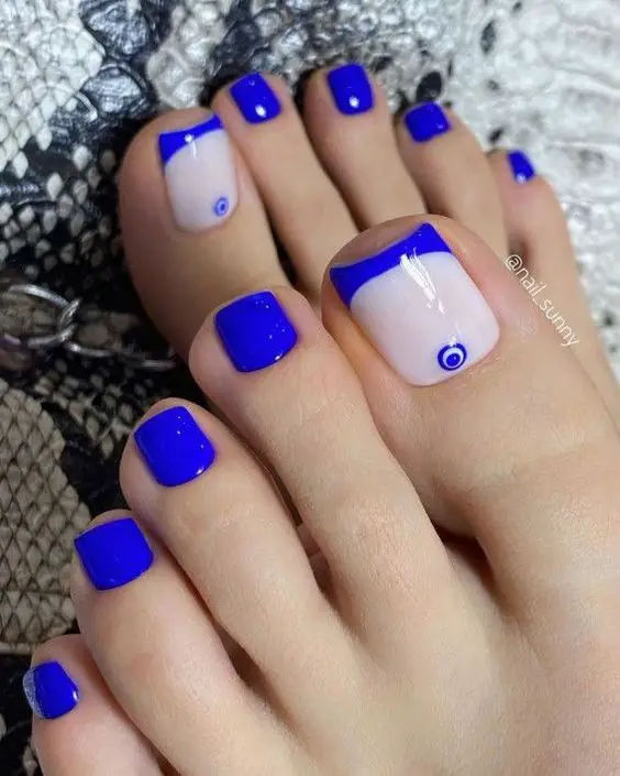 unhas vibrantes dos pés com esmalte azul e olho grego
